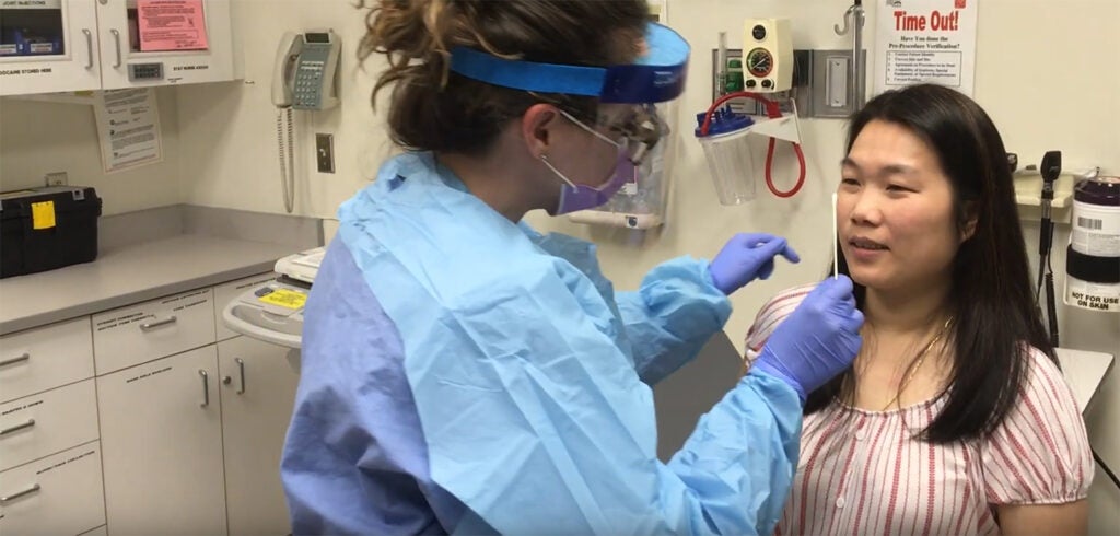 A non-English-speaking patient undergoes a nasal swabbing at Harborview.