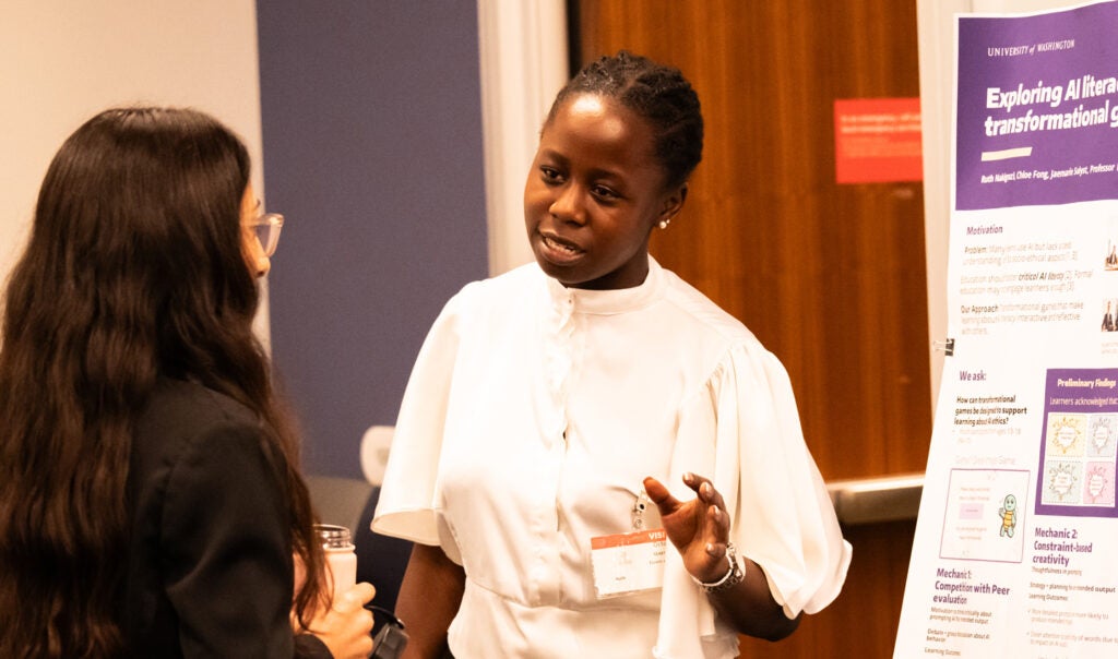 A presenter at the RAISE expo speaks to an attendee.